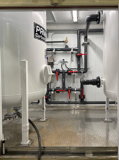 Interior view of PRM containerized water treatment enclosure with control panel and piping systems