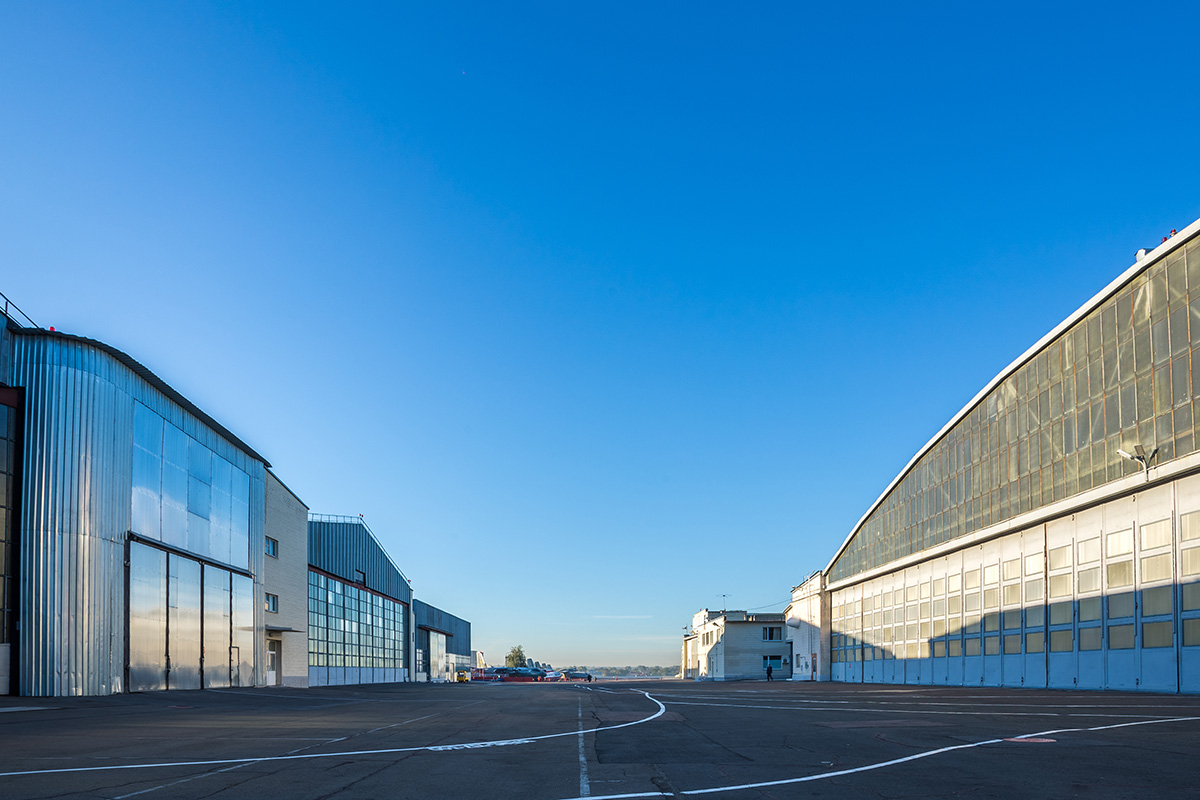 Aircraft hangars lining the apron of a military airfield — DoD installations where AFFF firefighting foam was used for decades, creating PFAS groundwater contamination
